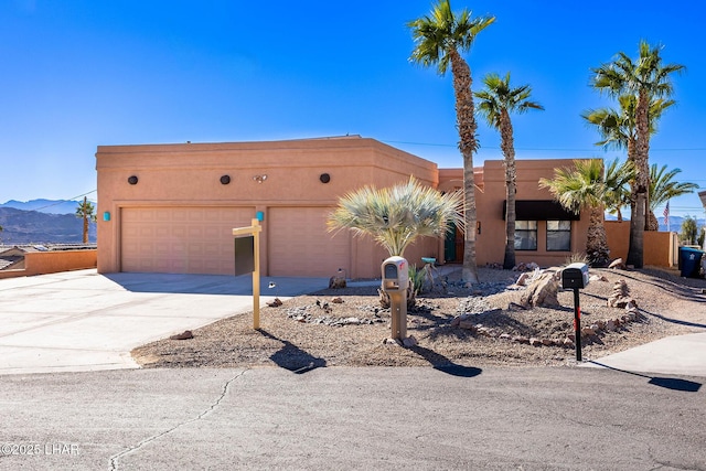 875 Wallingford Pl, Lake Havasu City, AZ 86406 - adobe home with concrete driveway, a garage, stucco siding, and a mountain view