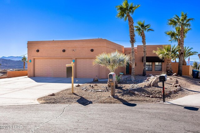 875 Wallingford Pl, Lake Havasu City, AZ 86406 - adobe home with concrete driveway, a garage, stucco siding, and a mountain view
