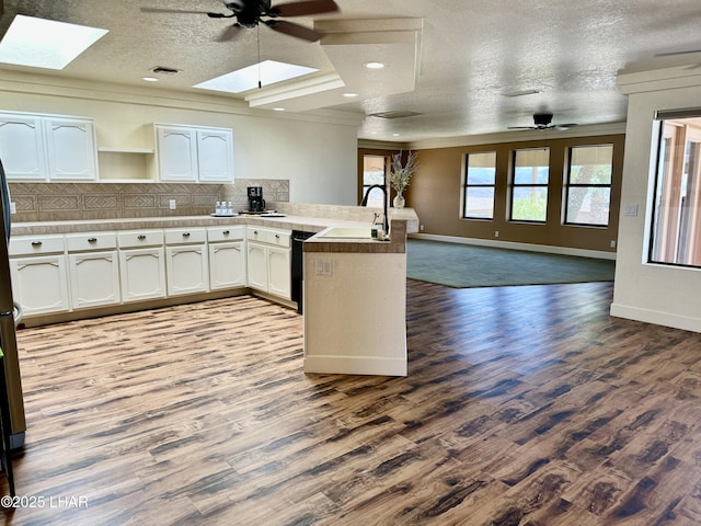 875 Wallingford Pl, Lake Havasu City, AZ 86406 - kitchen with a skylight, a peninsula, ceiling fan, open floor plan, and ornamental molding