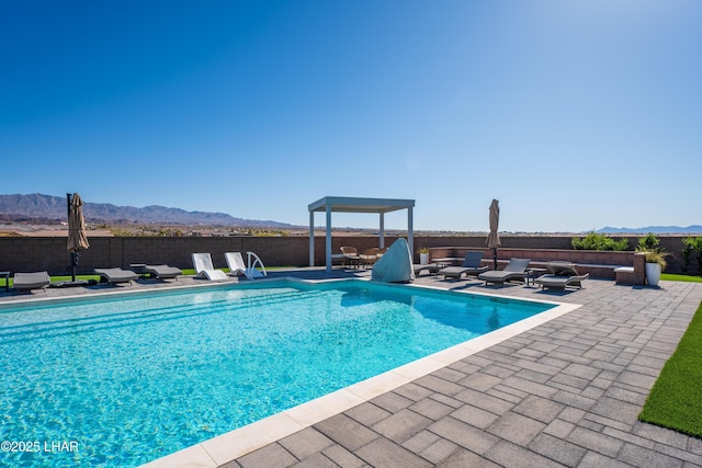 view of swimming pool with a mountain view and a patio area