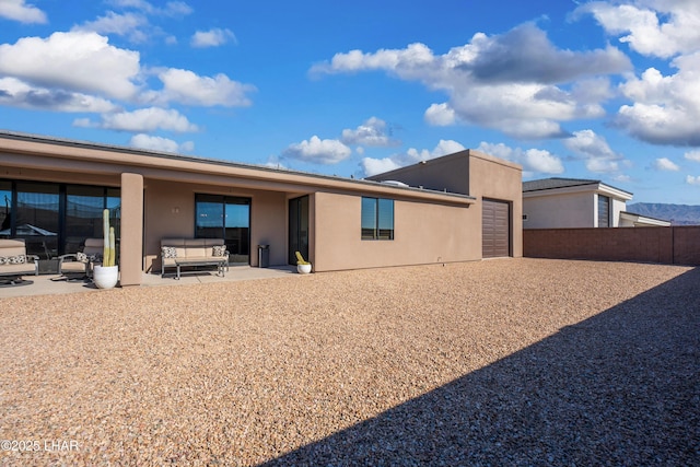 rear view of house with an outdoor living space and a patio