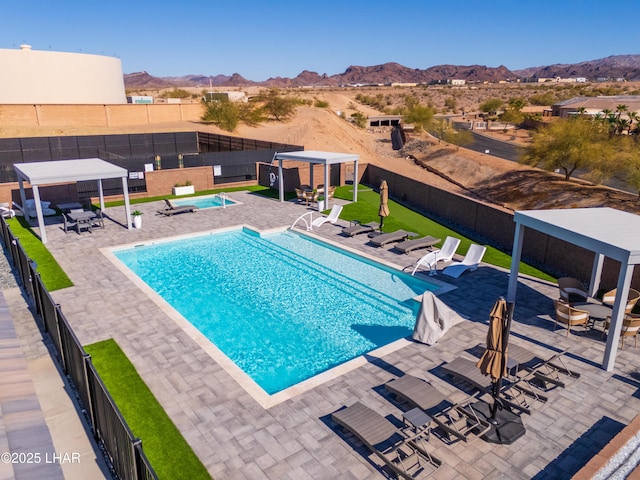 view of pool with a mountain view, a gazebo, a patio area, and an outdoor structure