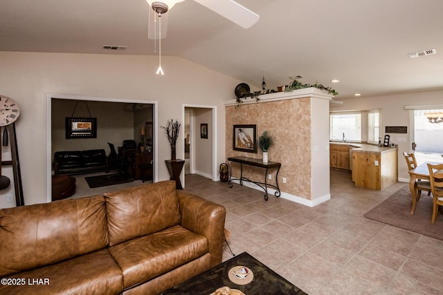 living room featuring lofted ceiling, light tile patterned floors, visible vents, and baseboards