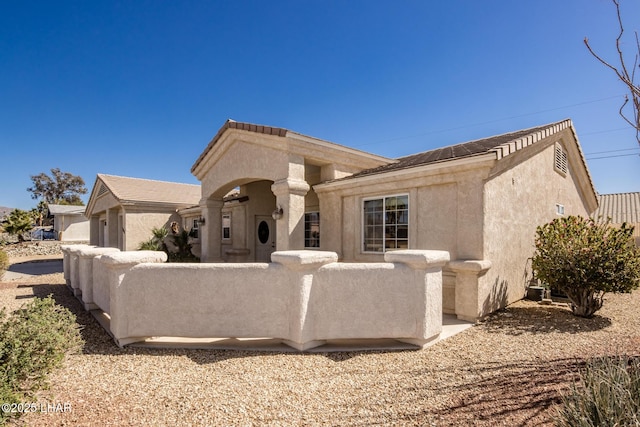 view of front of house with fence and stucco siding