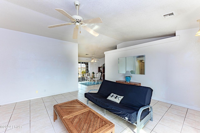 tiled living room featuring lofted ceiling, a textured ceiling, and ceiling fan