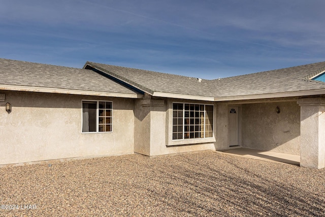 view of exterior entry with a patio area