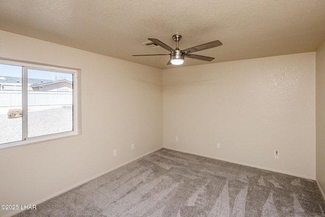 carpeted empty room with baseboards, a textured ceiling, and a ceiling fan