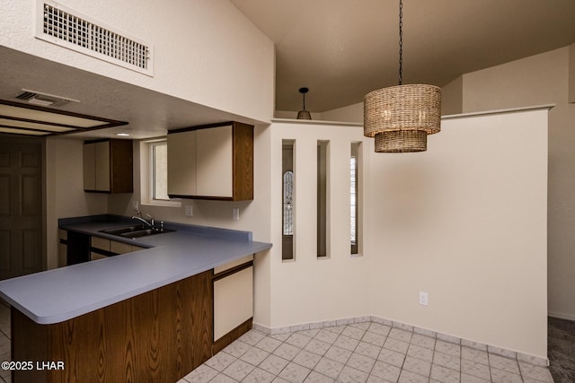 kitchen featuring a sink, visible vents, baseboards, and pendant lighting