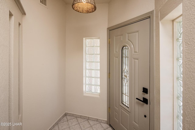 entrance foyer with light tile patterned flooring, visible vents, and baseboards