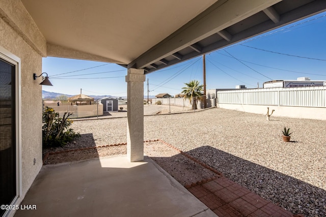 view of patio featuring an outdoor structure and a fenced backyard