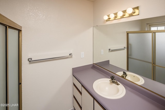 full bathroom featuring vanity and a shower with shower door