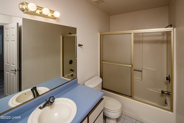 full bath featuring visible vents, toilet, shower / bath combination with glass door, tile patterned flooring, and vanity