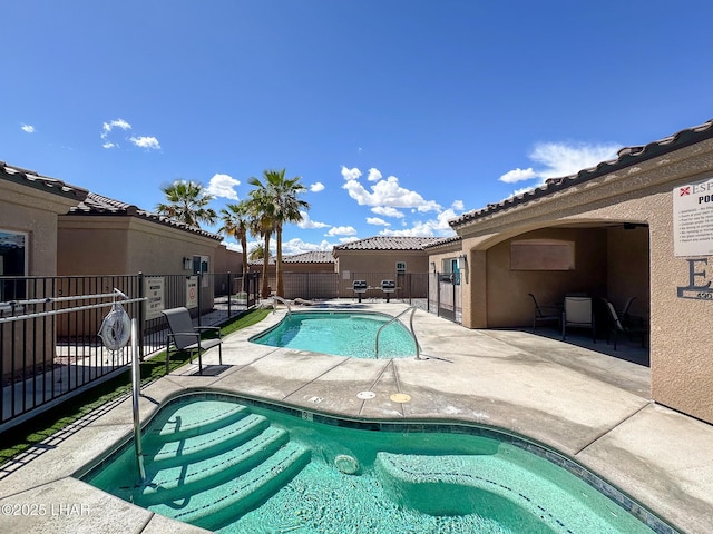 community pool with a patio and fence