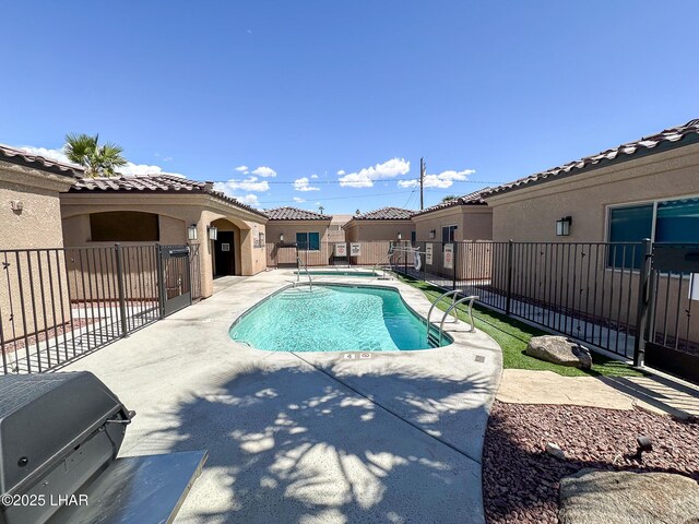 pool with a patio and fence