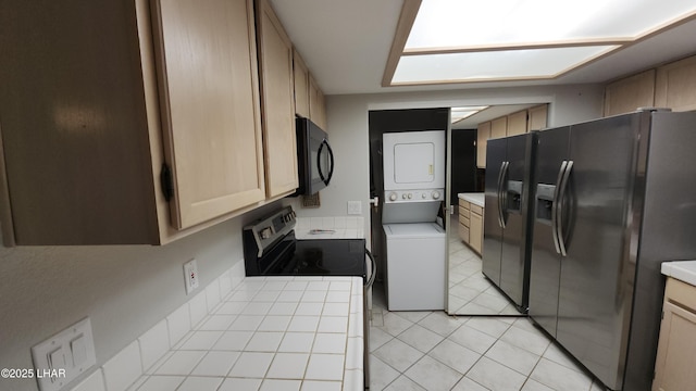 2095 Mesquite Ave Unit 27, Lake Havasu City, AZ 86403 - kitchen with stacked washer / dryer, black microwave, fridge with ice dispenser, electric range, and tile countertops