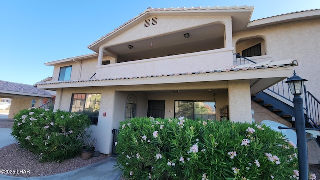 2095 Mesquite Ave Unit 27, Lake Havasu City, AZ 86403 - view of front facade featuring stairway, stucco siding, and a balcony