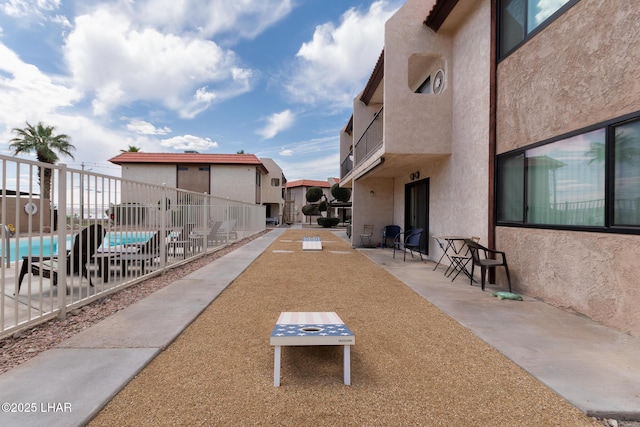 view of home's community with a patio, fence, a residential view, and a pool