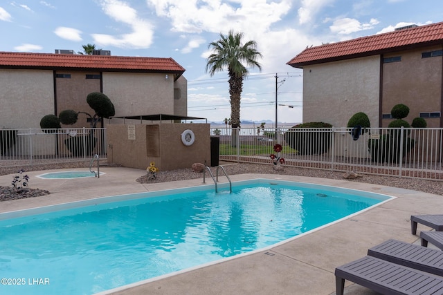 pool with fence and a patio