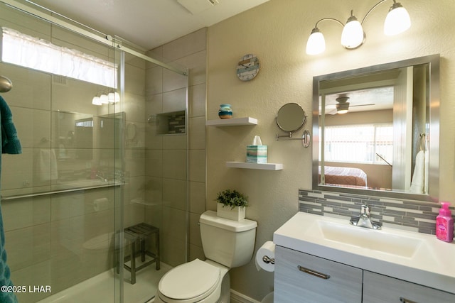 bathroom featuring toilet, a textured wall, and a stall shower