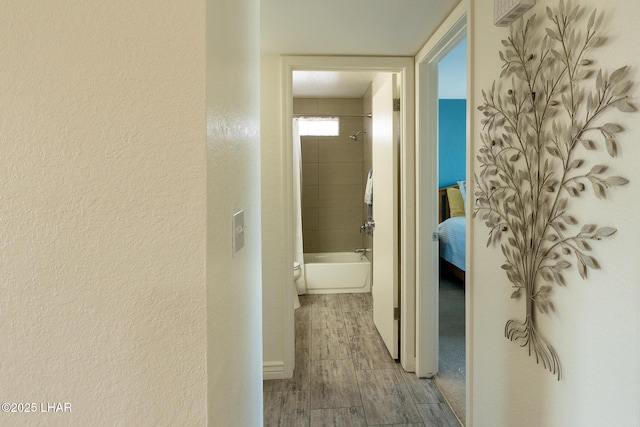 corridor featuring a textured wall and wood finished floors