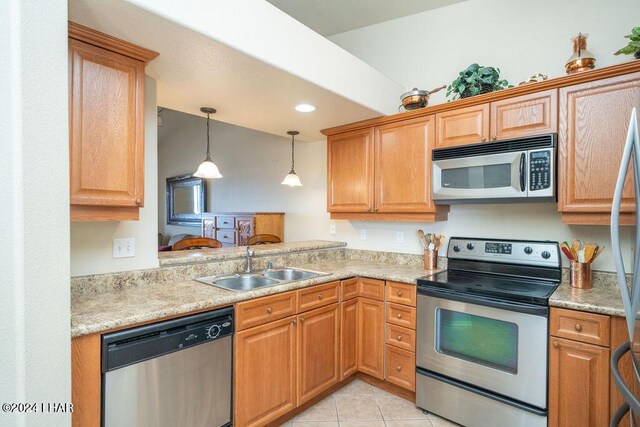 kitchen with sink, light tile patterned floors, stainless steel appliances, and hanging light fixtures