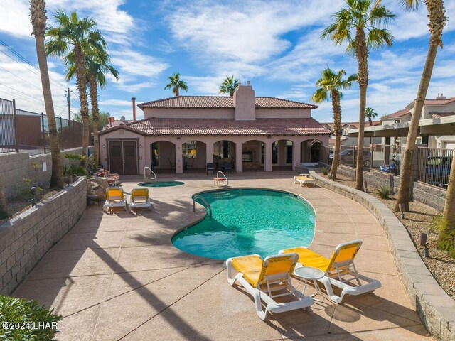 view of swimming pool with a patio and a community hot tub