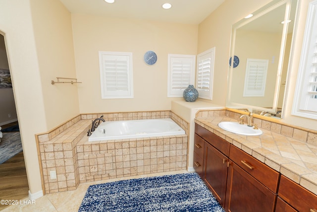 bathroom with recessed lighting, vanity, a bath, and tile patterned floors