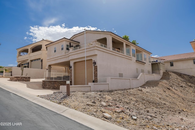 view of front facade with a balcony and stucco siding