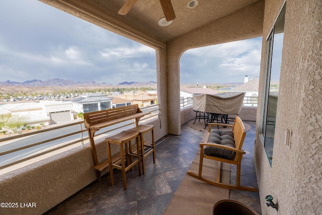 balcony featuring ceiling fan, a mountain view, and a residential view