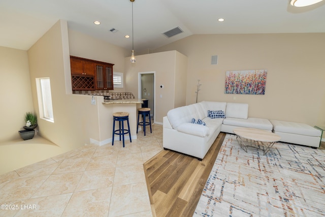 living room featuring lofted ceiling, visible vents, recessed lighting, and light tile patterned floors