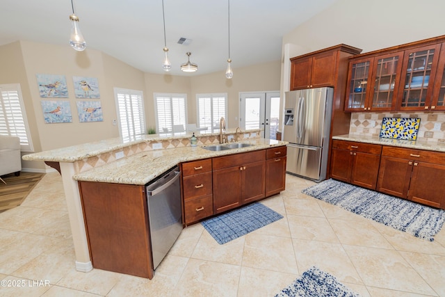 kitchen featuring visible vents, a sink, a kitchen island with sink, stainless steel appliances, and backsplash