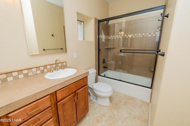 full bath with shower / bath combination with glass door, vanity, toilet, and tile patterned floors