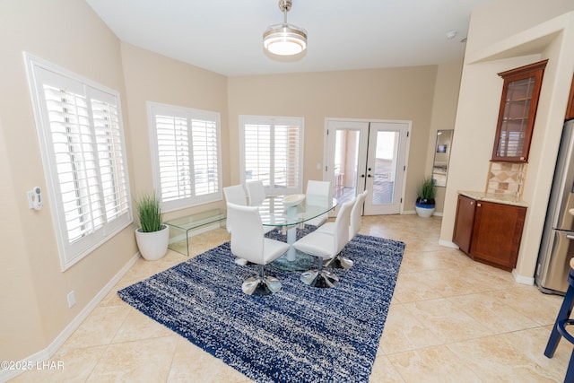 dining space featuring light tile patterned floors, baseboards, and french doors