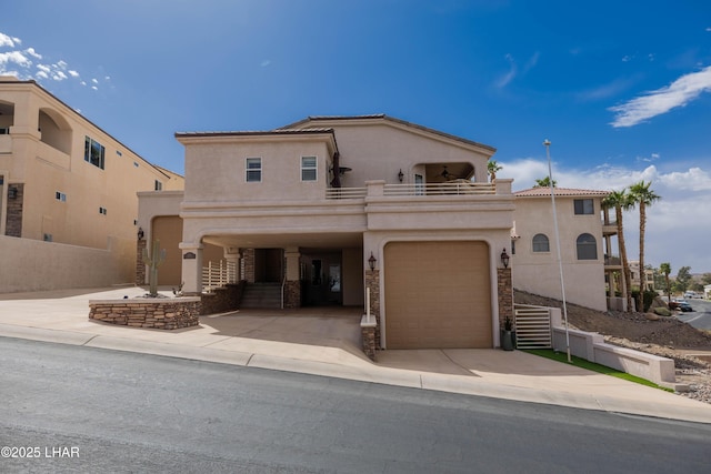 mediterranean / spanish-style home with a balcony, concrete driveway, and stucco siding