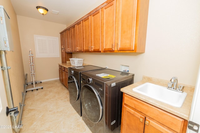 laundry room featuring cabinet space, baseboards, a sink, and washing machine and clothes dryer