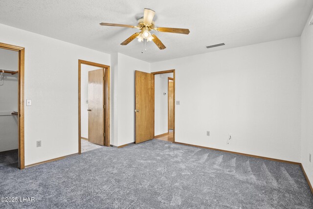 carpeted empty room with ceiling fan and a textured ceiling