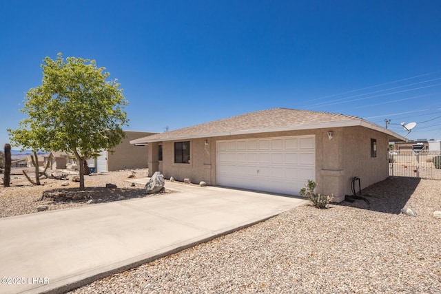 ranch-style house featuring an attached garage, roof with shingles, fence, and concrete driveway