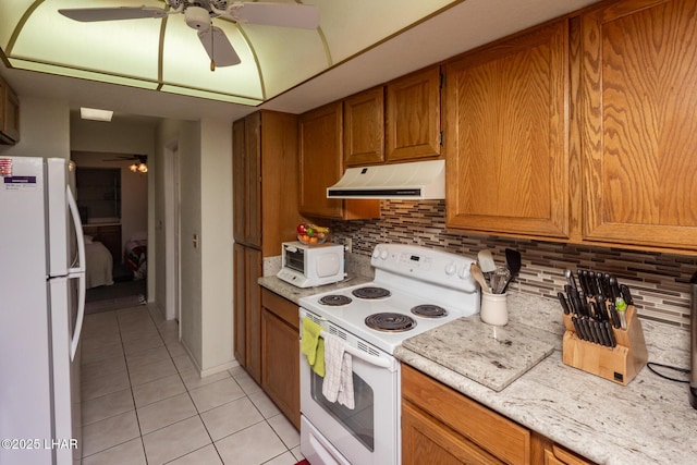 kitchen with light tile patterned flooring, white appliances, range hood, light countertops, and a ceiling fan