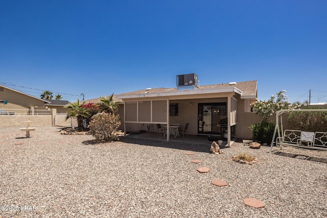 rear view of house featuring fence, a patio, stucco siding, and central AC