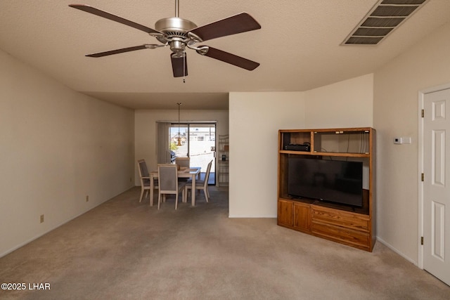 carpeted living room featuring ceiling fan and visible vents