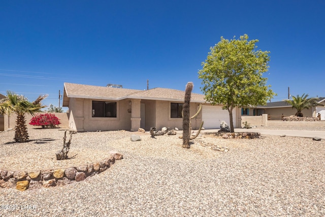 ranch-style home with a garage and stucco siding