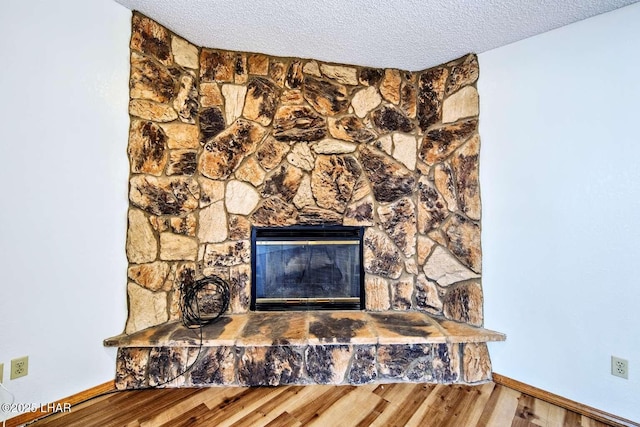 interior details featuring hardwood / wood-style flooring, a textured ceiling, and a fireplace