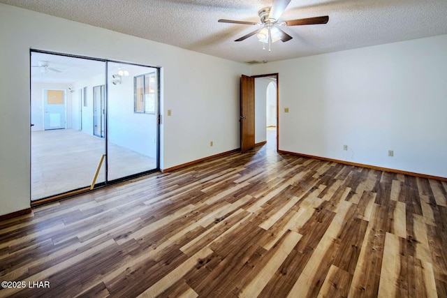 unfurnished bedroom featuring ceiling fan, wood-type flooring, and a textured ceiling