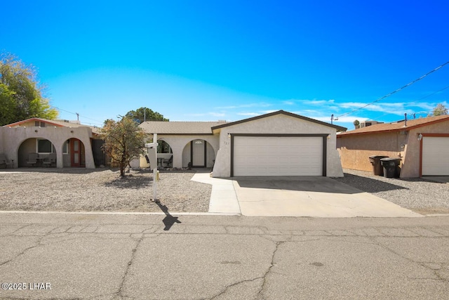 view of front facade featuring concrete driveway, an attached garage, and stucco siding