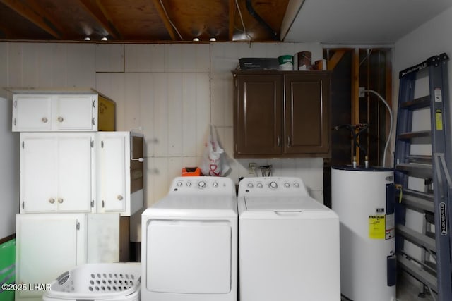 washroom with cabinet space, water heater, and separate washer and dryer