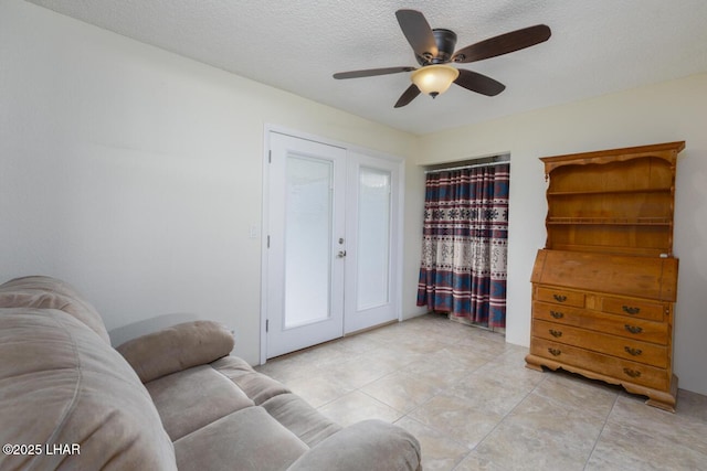 sitting room featuring ceiling fan, a textured ceiling, and light tile patterned floors