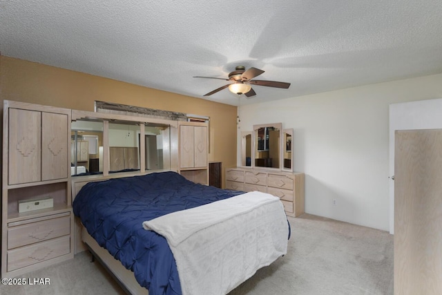 carpeted bedroom featuring ceiling fan and a textured ceiling