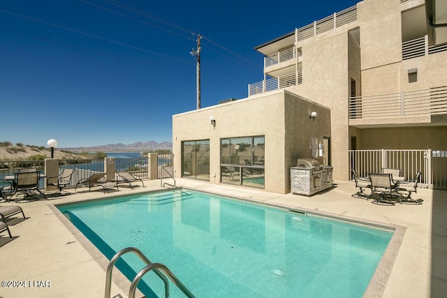 view of swimming pool with a mountain view, area for grilling, and a patio area