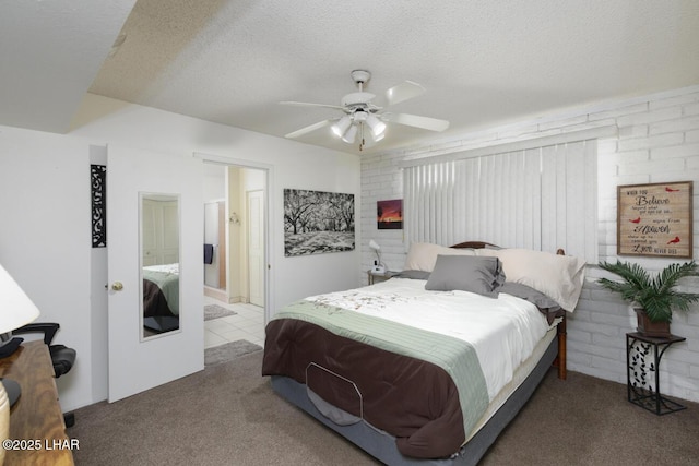 carpeted bedroom with ceiling fan, ensuite bath, and a textured ceiling