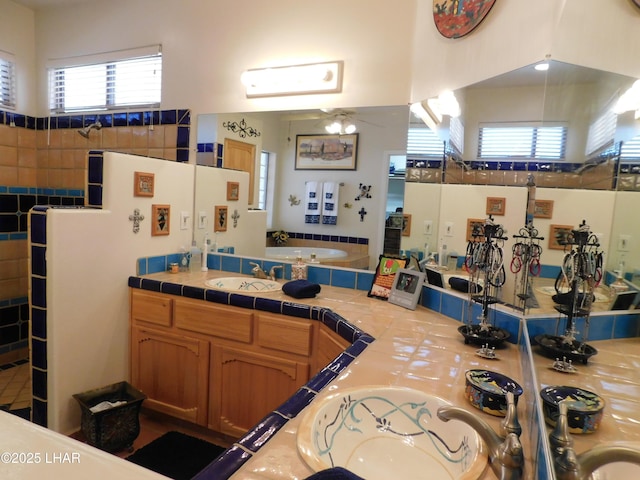 interior space with sink, tile counters, and ceiling fan